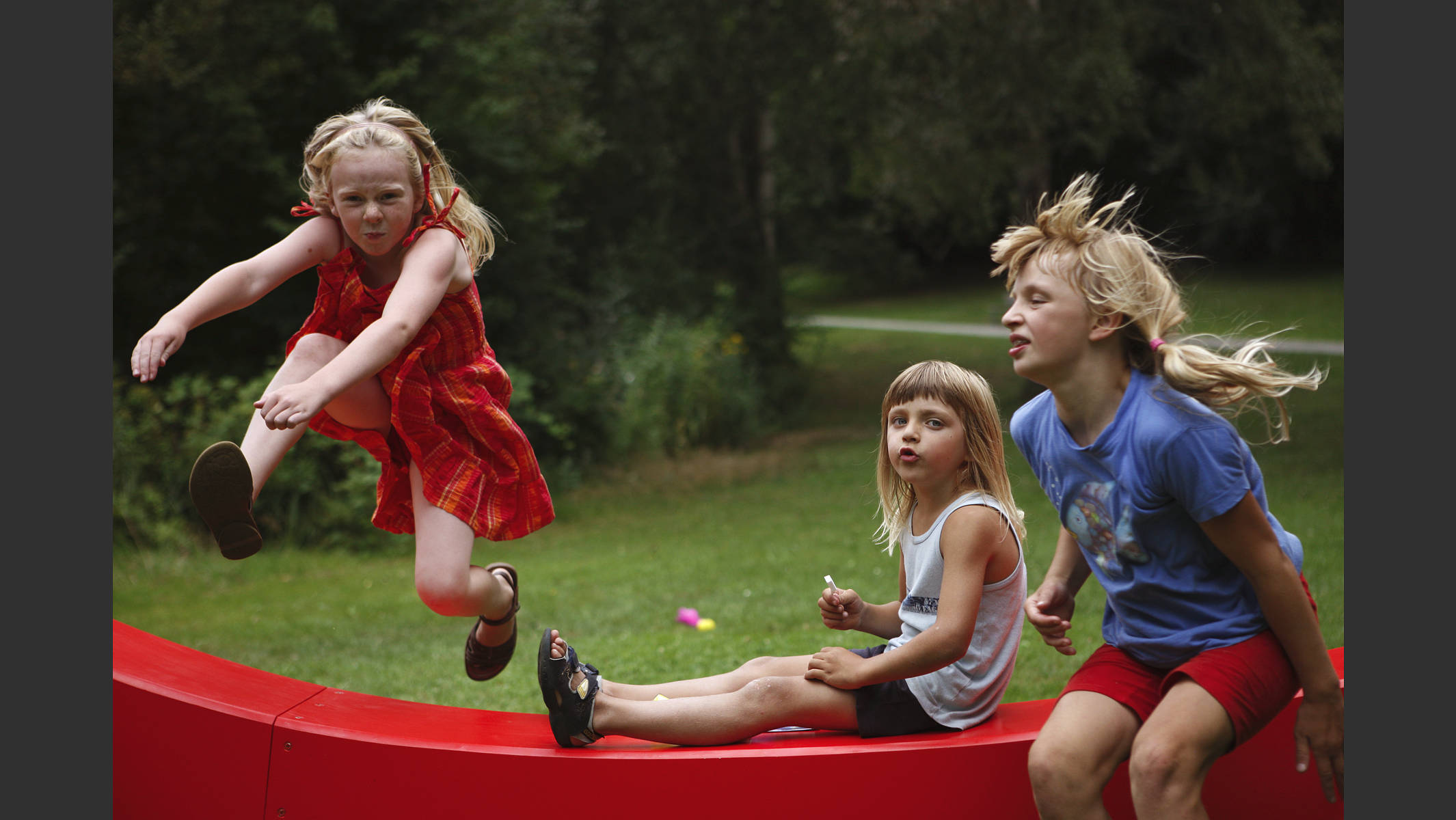 Drei Kinder, die über das VAG-Zeichen springen. © Martin Geier